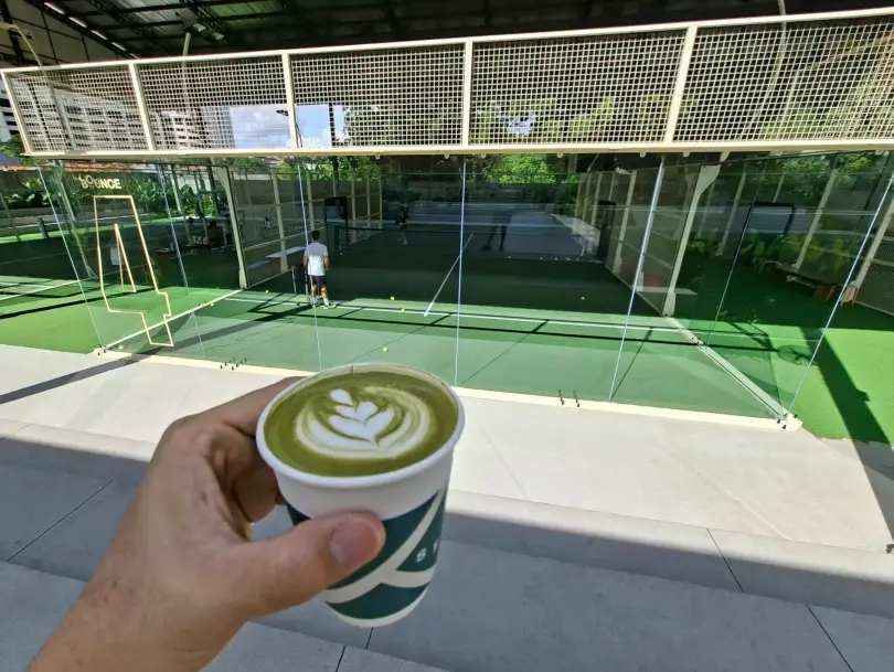 A matcha latte with the courts behind